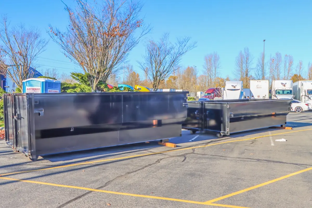 Professional dumpster rental service with roll-off container on residential driveway in Amory